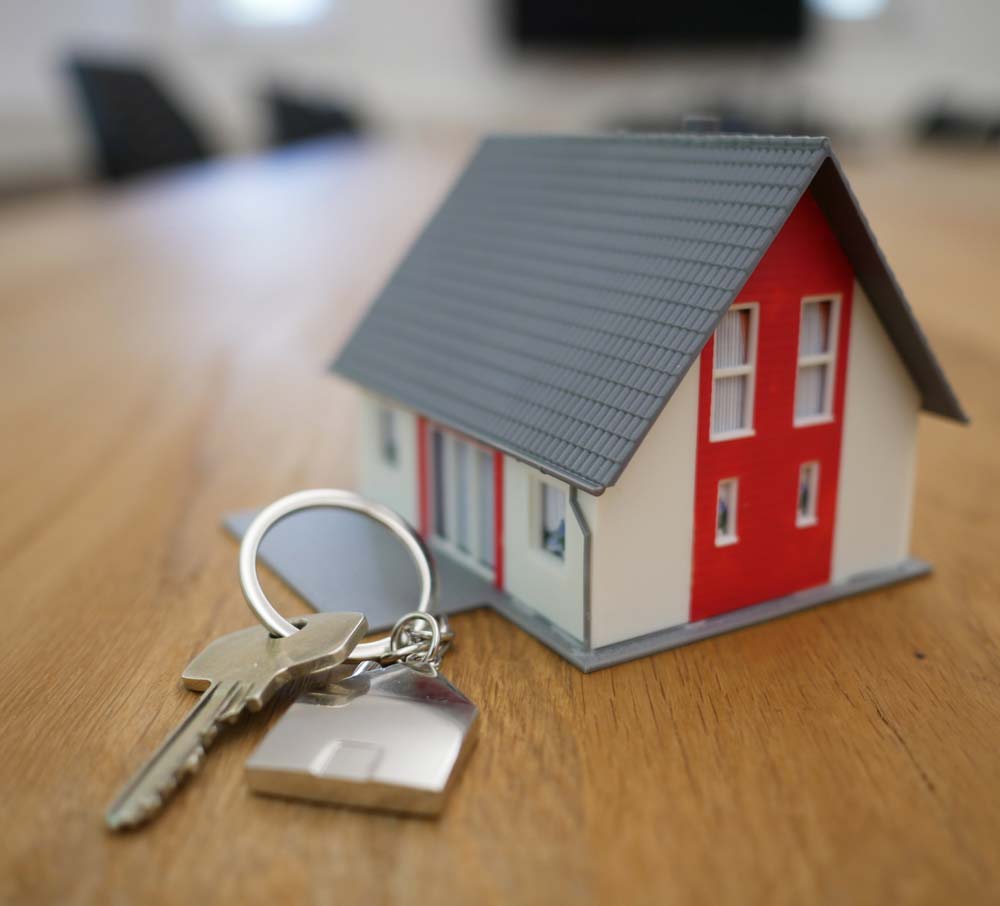 Keys next to a model house