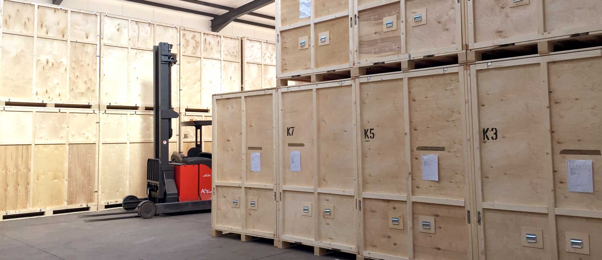 Forklift truck alongside storage containers